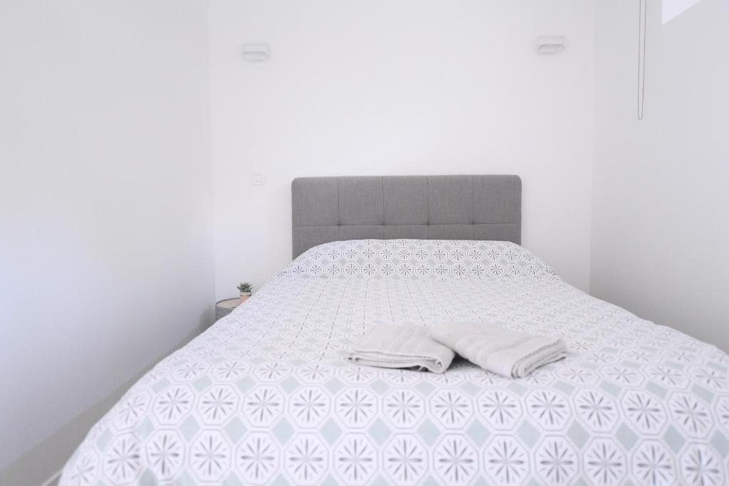Una cama blanca con dos almohadas blancas. en A la meulière d'Orsay, vue sur la vallée, au calme en Orsay