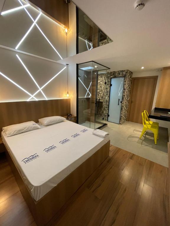 1 dormitorio con 1 cama grande y 1 silla amarilla en Hotel Cantareira (Adults Only), en São Paulo