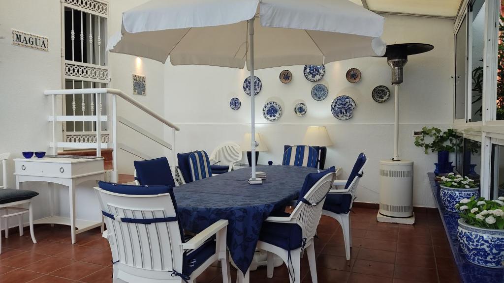 ein Esszimmer mit einem Tisch, Stühlen und einem Sonnenschirm in der Unterkunft VCV Villa Magua in Santa Brígida