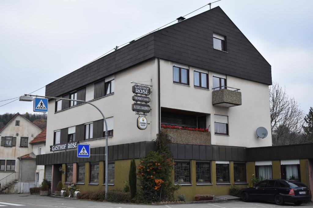 een groot wit gebouw met een zwart dak bij Gasthof Rose in Reutlingen