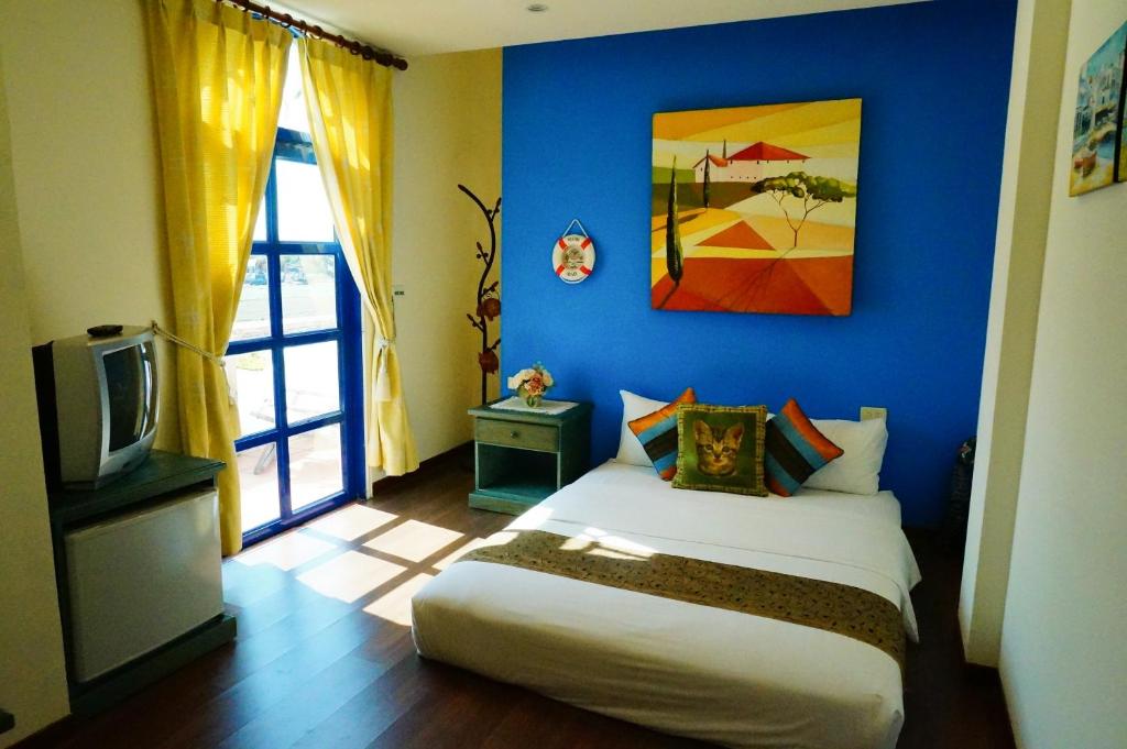 Habitación azul con cama y TV en Sine Ya Hostel, en Hengchun