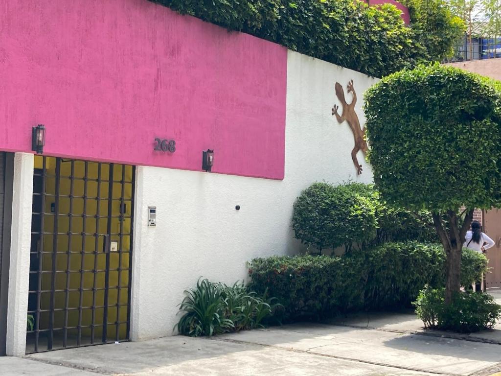 een roze en wit gebouw met een deur met een hert erop bij Hostal Cuija Coyoacan Berlin 268 Coyoacan in Mexico-Stad