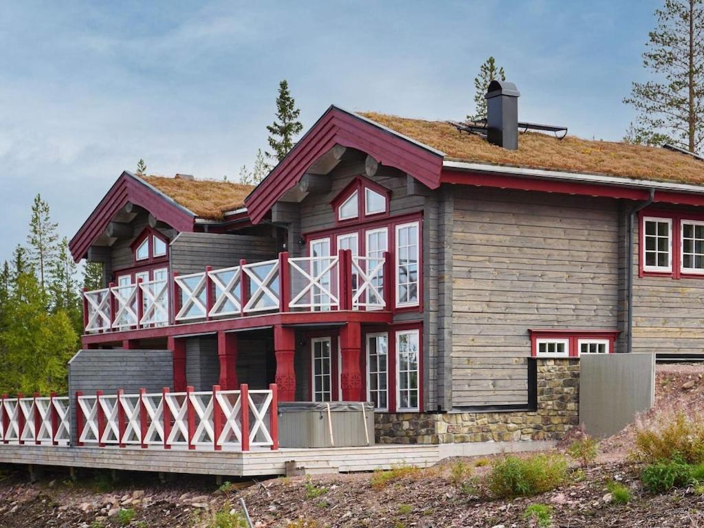 ein Haus mit roter Ausstattung und einem rot-weißen Balkon in der Unterkunft 8 person holiday home in S LEN in Sälen