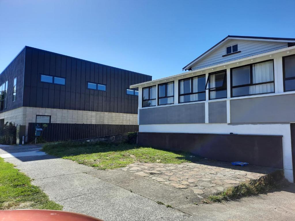 a building next to a sidewalk next to a building at Central Holiday Home in Tauranga