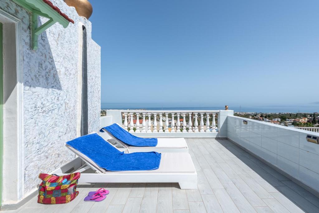 a pair of blue lounge chairs on a balcony at Room in Studio - Senior Citizen Suite in blue in Hersonissos