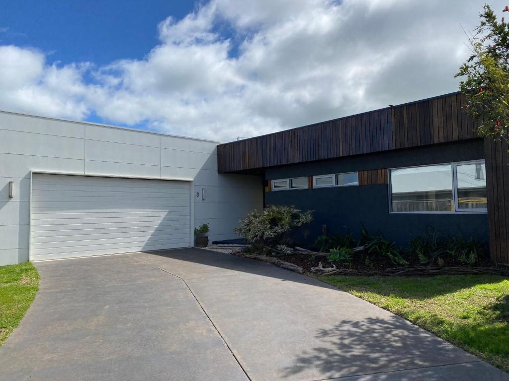 a house with a garage and a driveway at Sunnyside Surf Side in Inverloch