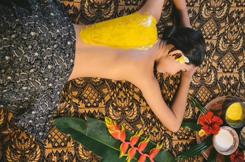 a woman in a yellow dress laying on the floor at Sri Phala Resort & Villa in Sanur