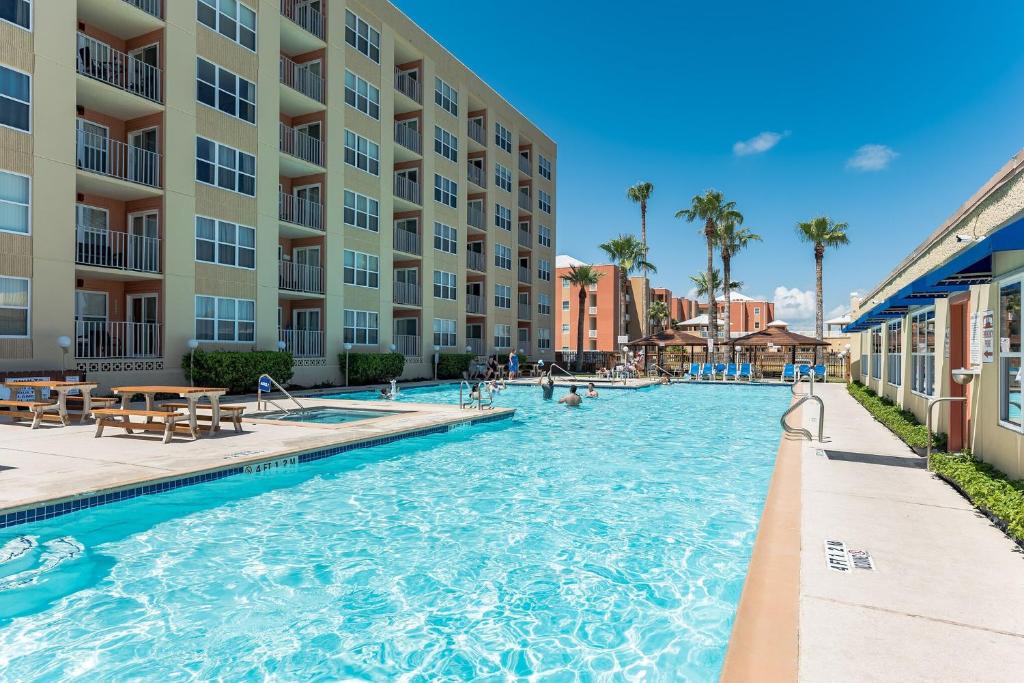 uma piscina num resort com pessoas em Charming 1 Bedroom, 3 Minute Walk To The Beach Condo em South Padre Island
