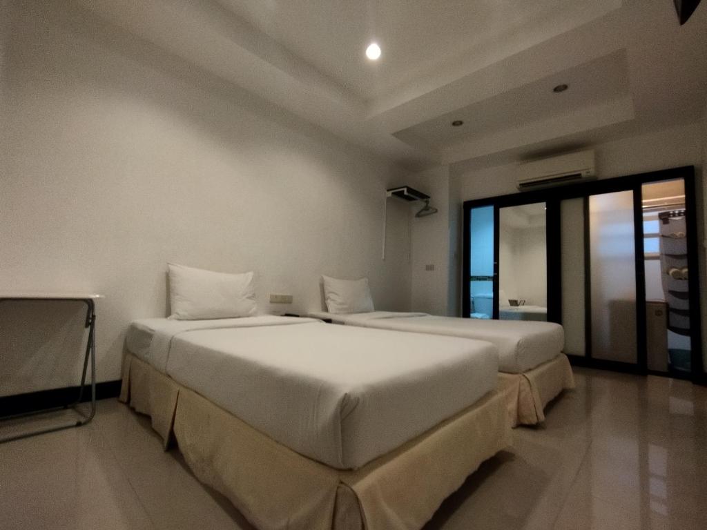 two beds in a room with two windows at The Auto Place in Ban Sam Kong