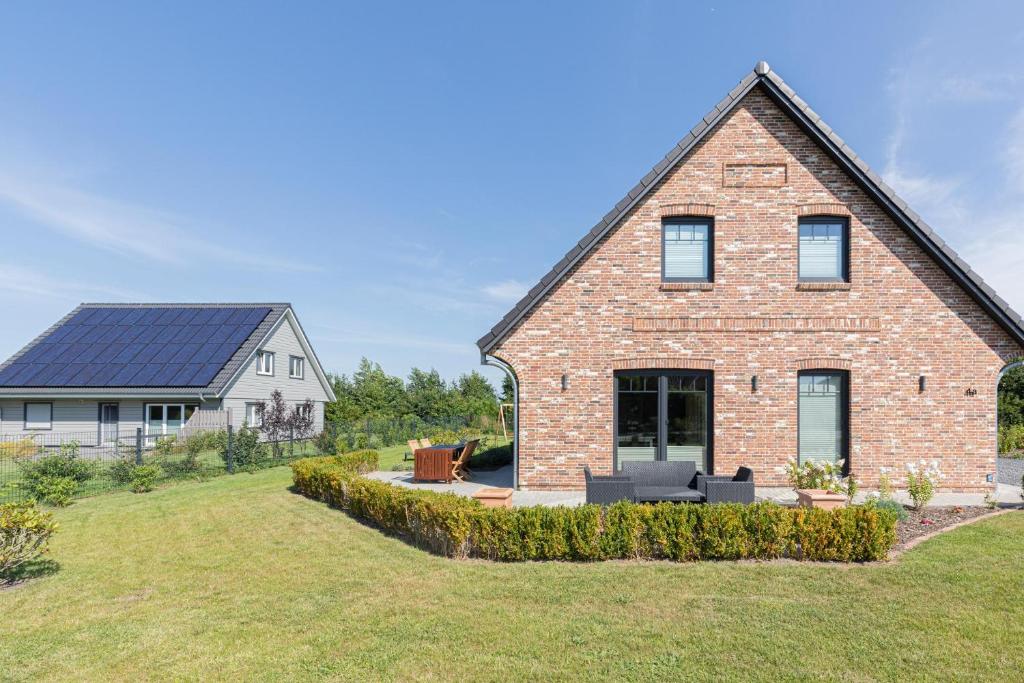 een groot bakstenen huis met een zonnedak bij Nordwind in Braderup