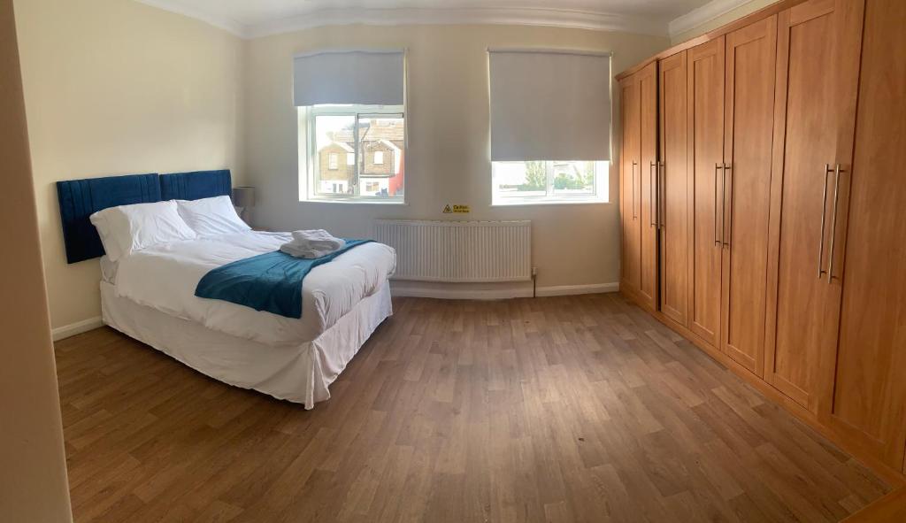 1 dormitorio con 1 cama grande y armario de madera en Beautiful 6 Bedroom with spacious Lounge & Rooms Free parking, en Erith