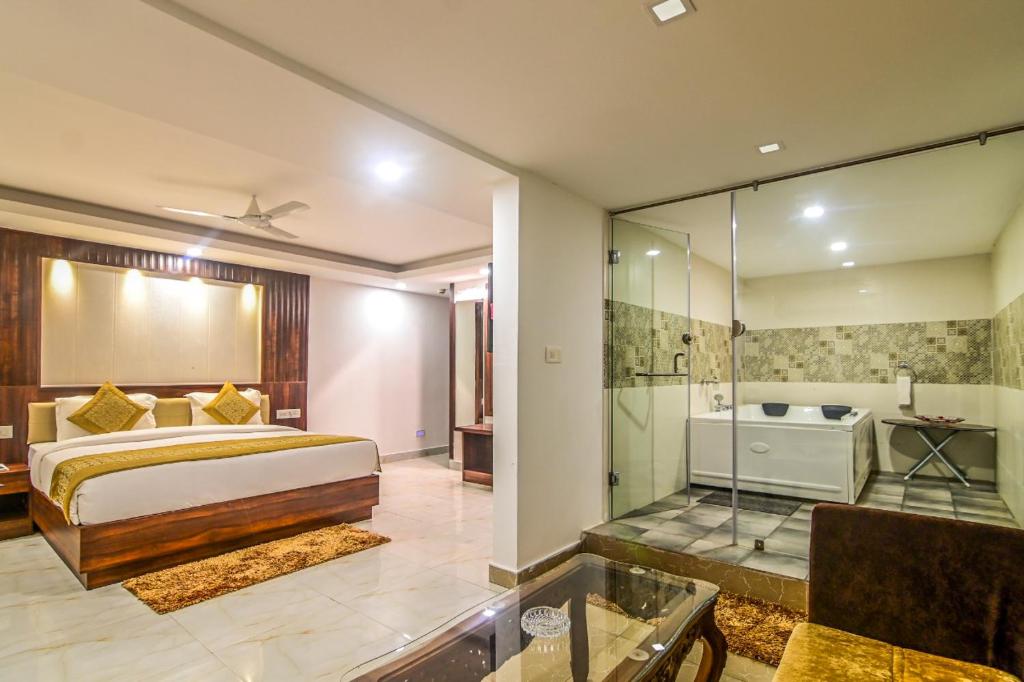 a bedroom with a king sized bed and a shower at De Falcon Goa Beach Resort in Candolim