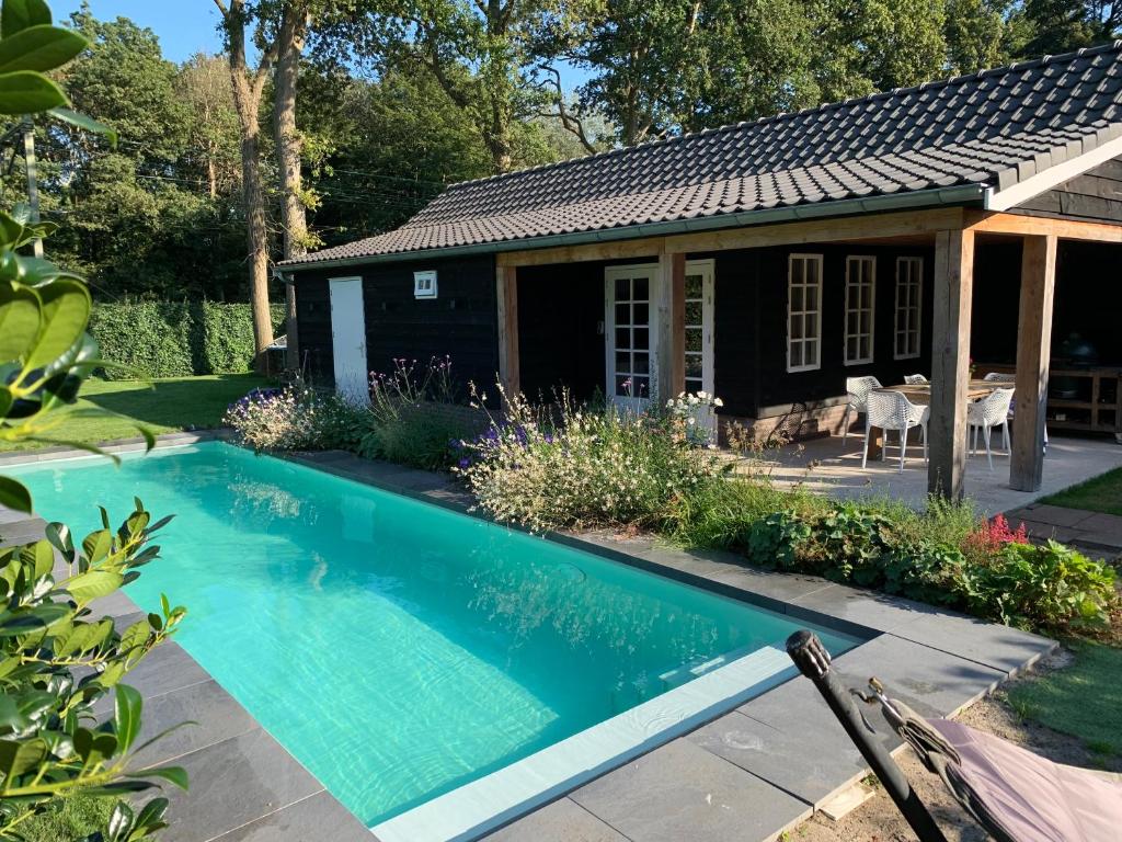 a swimming pool in front of a house at Chalet Santpoort-Zuid in Santpoort-Zuid