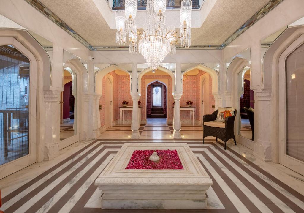 a large room with a chandelier and a fountain at Surya Haveli , Amer Fort Jaipur in Jaipur