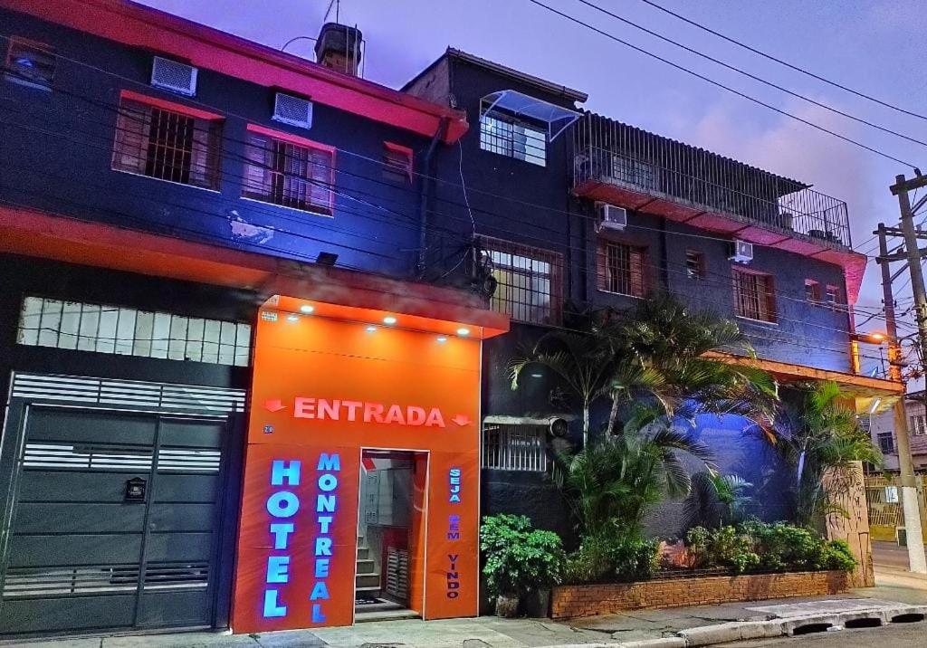 um edifício com um sinal laranja à frente em Hotel Montreal em São Paulo