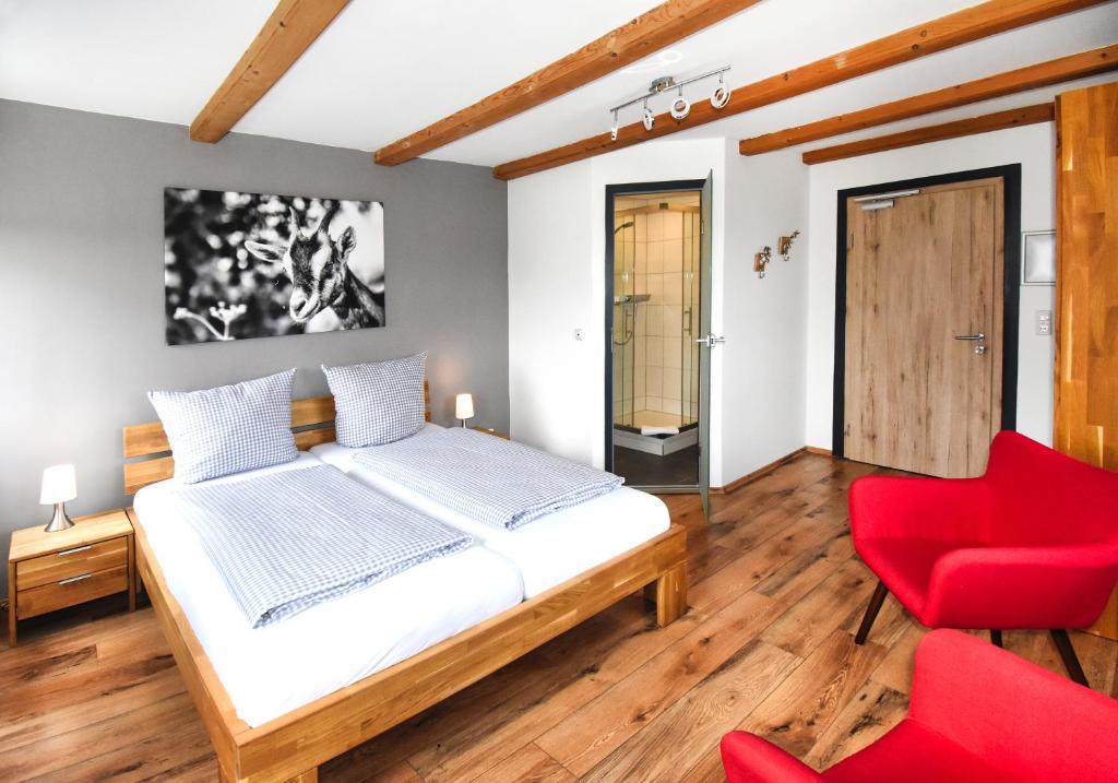 a bedroom with a bed and a red chair at 8peaks in Pfronten