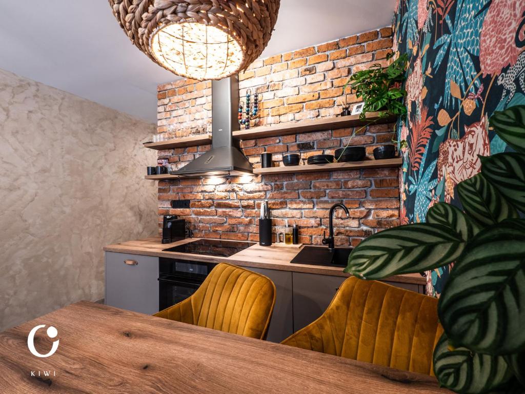 a kitchen with a table and a brick wall at JUMBO APARTMENTS in Rajecké Teplice
