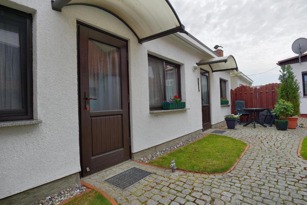 uma casa branca com uma porta castanha e um pátio em Barth, Dieter em Zingst