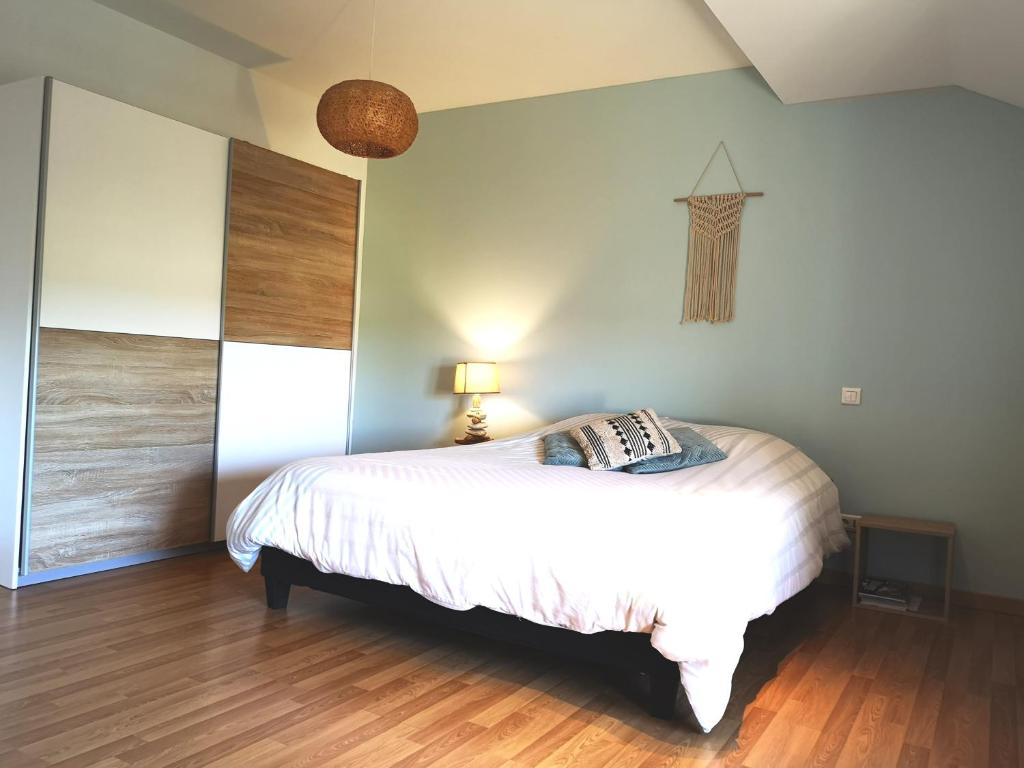 1 dormitorio con cama blanca y suelo de madera en Emel b&b, en Laville-aux-Bois