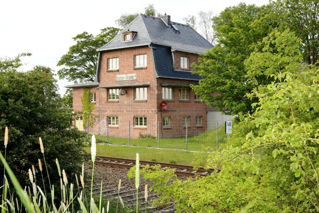 a large brick house with a black roof at Bahnhof Hohen Mistorf in Hohen Mistorf