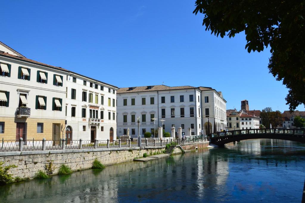 a bridge over a river in a city with buildings at Riviera Garibaldi in Treviso