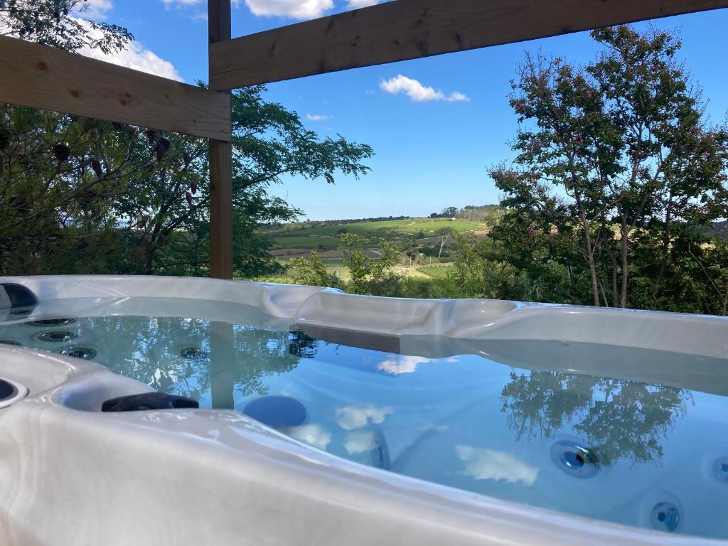 a jacuzzi tub with a view of the countryside at Nuitées Bohèmes in Gajan