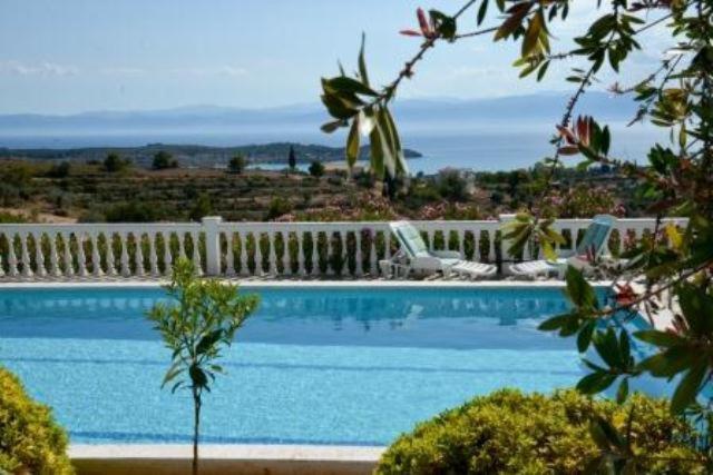 uma grande piscina com uma cerca branca à volta em Iron Hill Pool Villa - Amazing Sunset & Sea View em Porto Heli