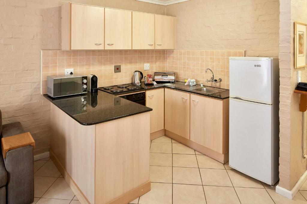 a kitchen with a white refrigerator and a sink at First Group Hastings Hall in Cape Town