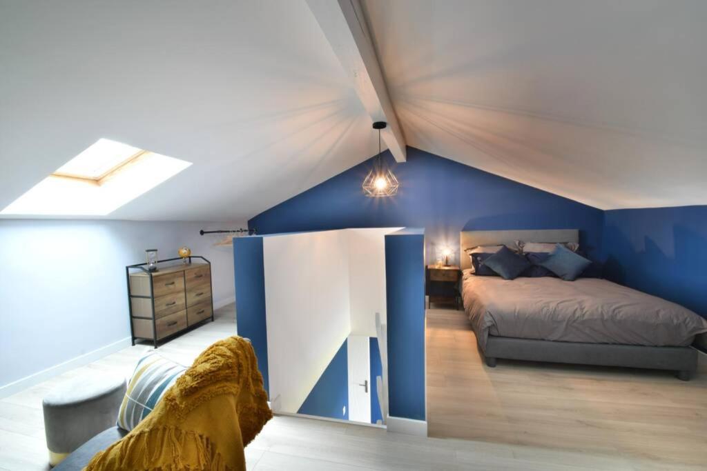 a bedroom with a bed and a blue wall at Domaine de Monplaisir82 in Montech