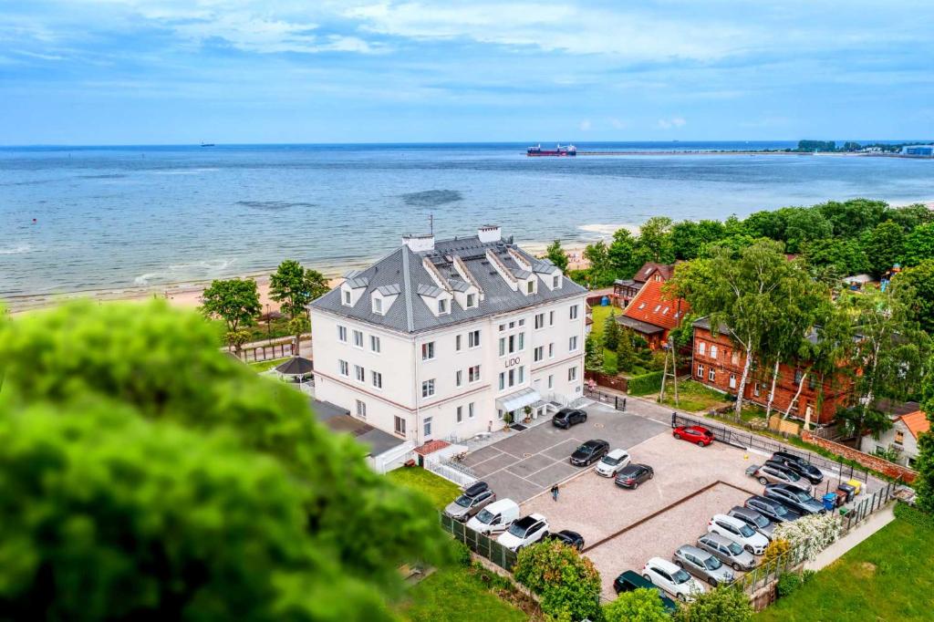 widok z powietrza na duży biały budynek obok wody w obiekcie Lido Dom Przy Plaży w Gdańsku