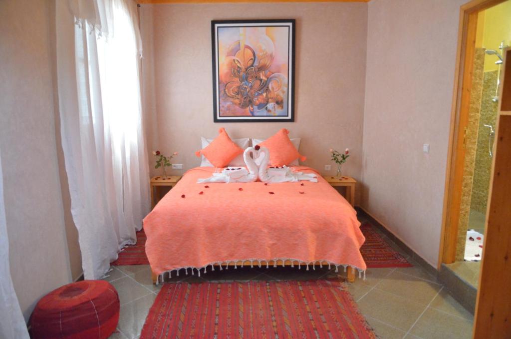 - une chambre avec un lit et une couverture orange dans l'établissement Riad Essaouira, à Essaouira