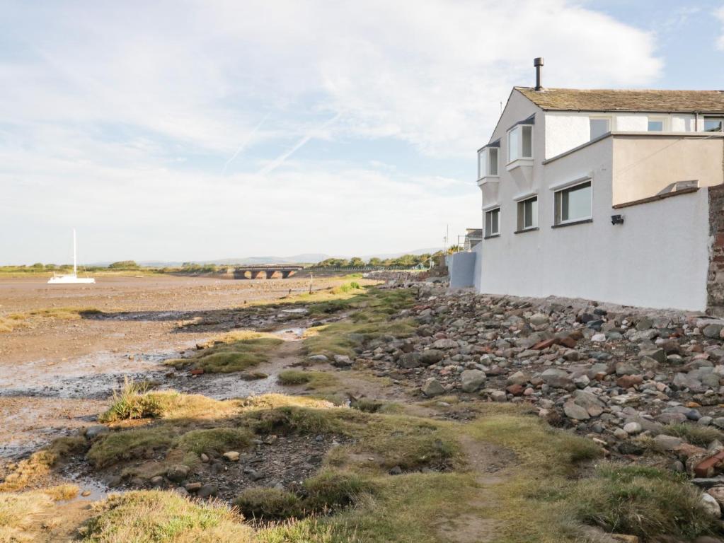 ein Haus auf den Felsen in der Nähe des Ozeans in der Unterkunft Waterside in Ravenglass