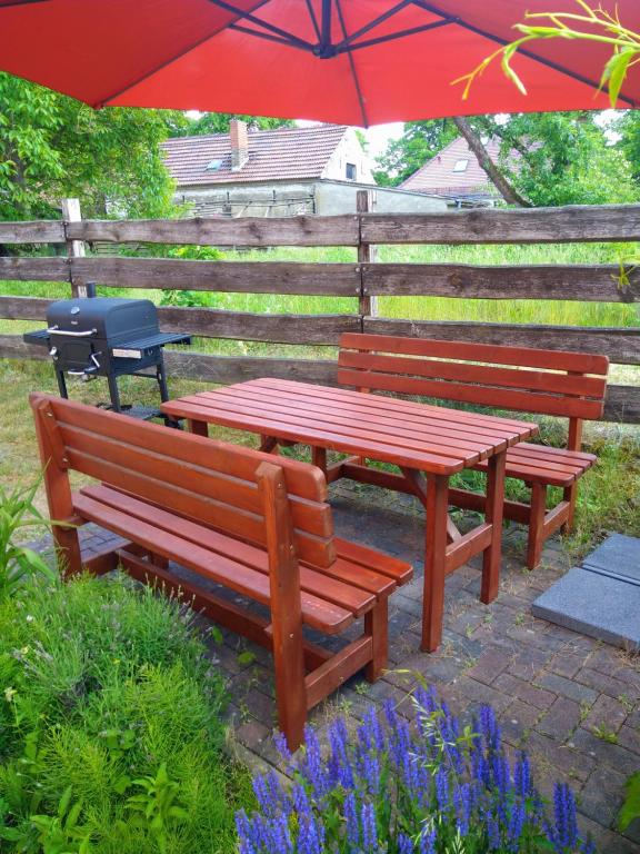 two benches and a picnic table under an umbrella at Dori's Fewo in Mittenwalde
