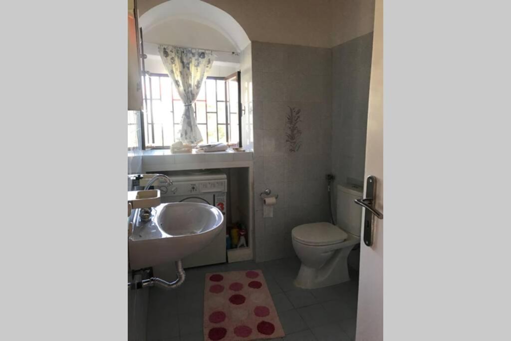 a bathroom with a sink and a toilet and a window at Anastasia’s Home in Oriá
