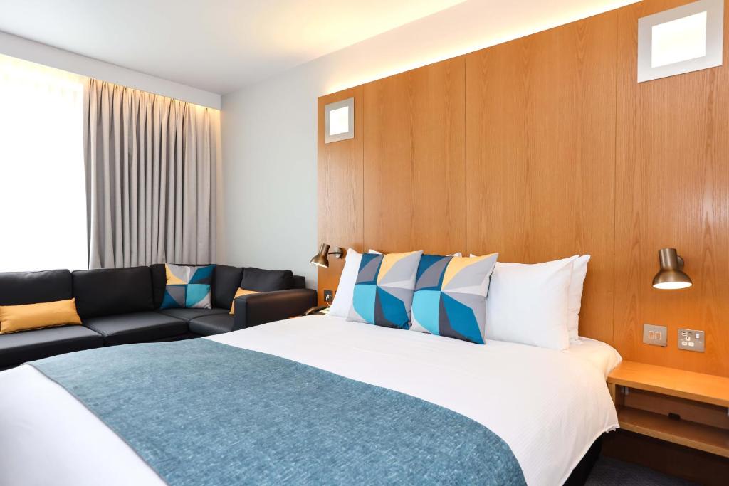 a hotel room with a bed and a couch at Holiday Inn Bournemouth by IHG in Bournemouth