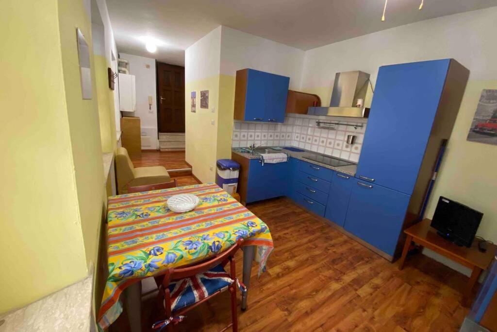 una cocina con armarios azules y una mesa con un mantel colorido. en Un tocco provenzale a Savigliano, en Savigliano