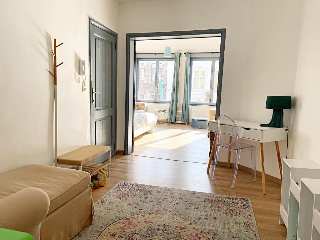 a living room with a bed and a desk and a room at The Bachelor Backpacker Spot in Brussels