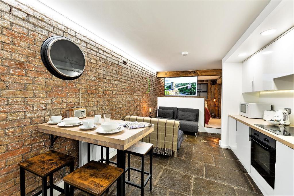 uma cozinha e sala de estar com uma parede de tijolos em St Michaels Place em Bristol
