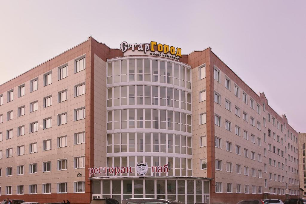 a large building with a sign on top of it at Stargorod Apart-Hotel in Kaluga