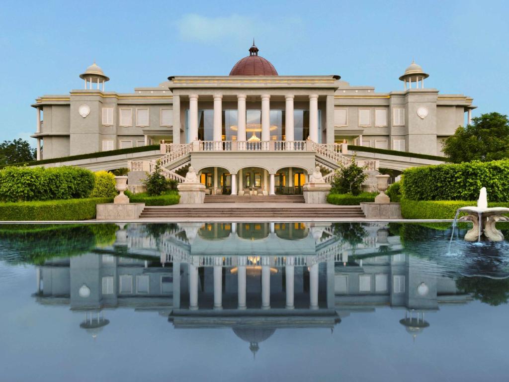 a building with a reflection in a pool of water at Raffles Udaipur in Udaipur