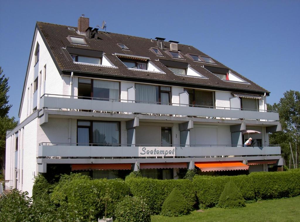 a large white building with a brown roof at Apartmenthaus Seetempel in Scharbeutz