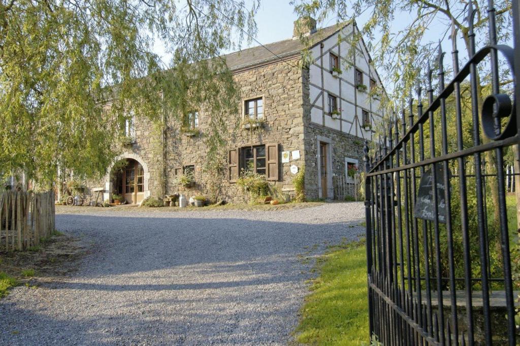 una entrada a un edificio de piedra con una puerta en B&B Le Clos de la Fontaine, en Chéoux