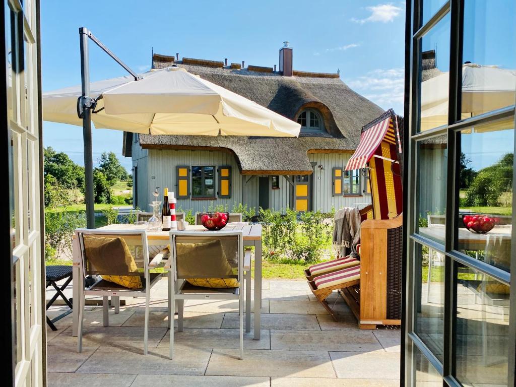 un patio con mesa y sombrilla en Feriendorf Klein Stresow Rügen, en Putbus