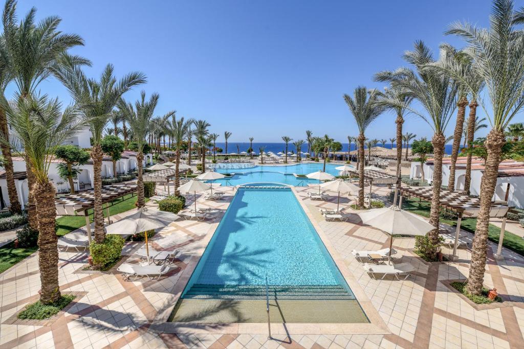 an aerial view of a resort pool with palm trees at Jaz Fanara Resort in Sharm El Sheikh