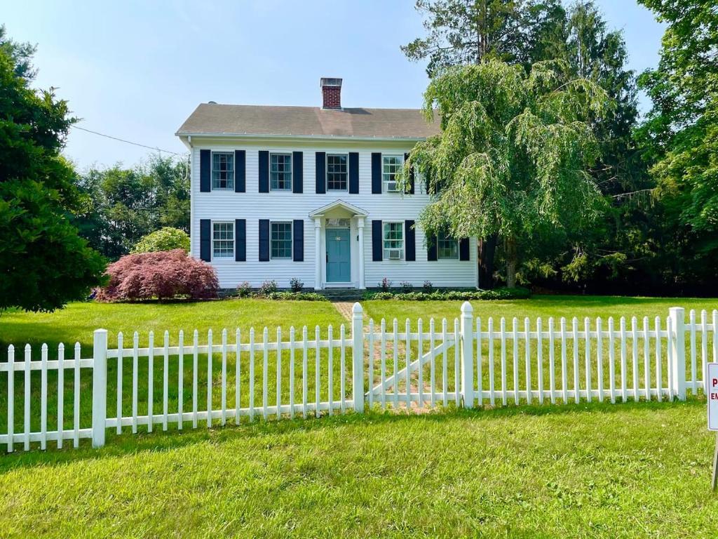 een wit hek voor een wit huis bij 1860's Colonial House Near Downtown and Beaches! in Madison