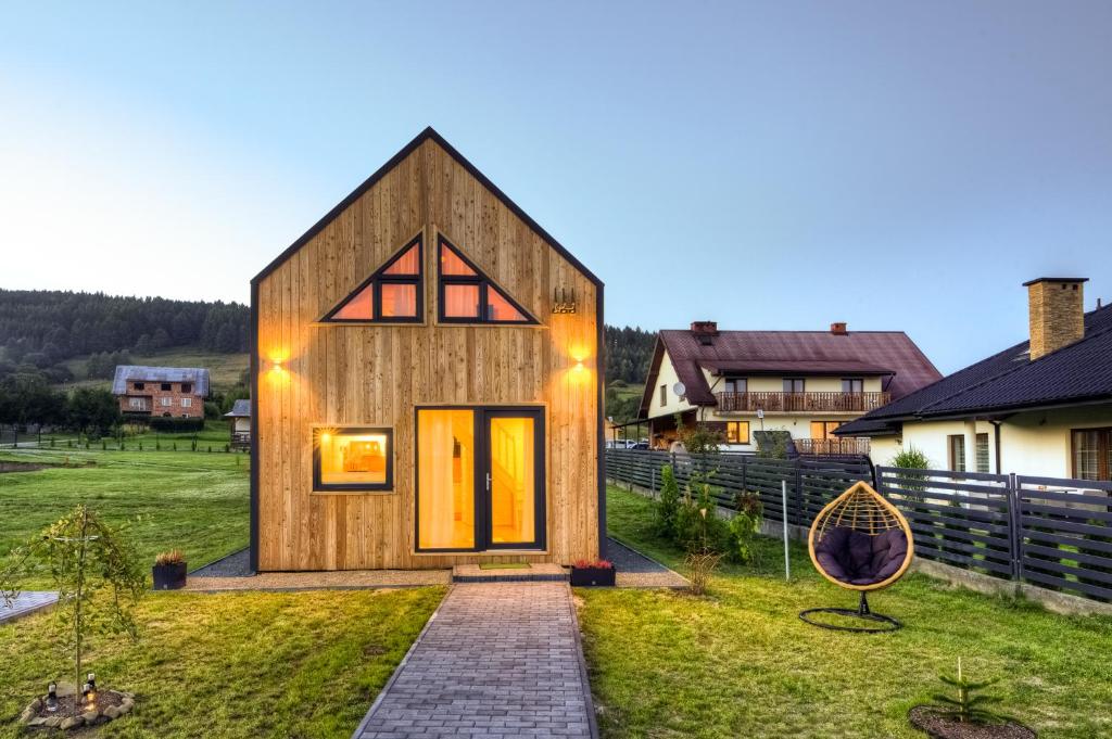 a small wooden house on a grassy field at Domki letniskowe w centrum Tylicza in Tylicz