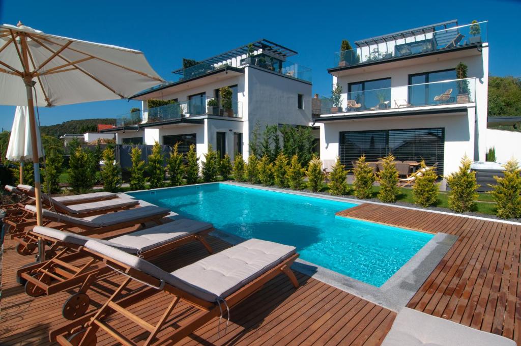 a villa with a swimming pool and a house at Skyline Resort in Balatonalmádi