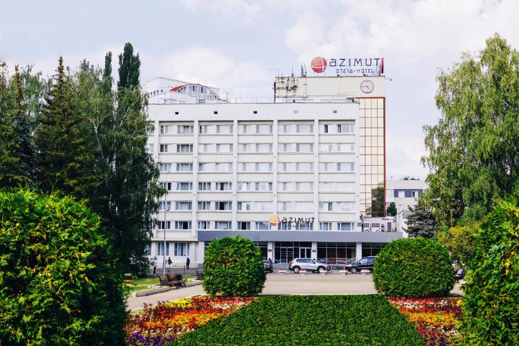 a large white building with a sign on top of it at AZIMUT Hotel Ufa in Ufa