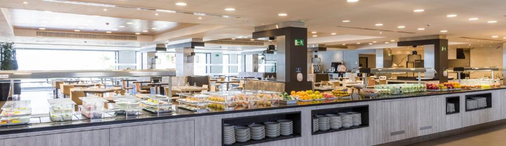 a buffet line in a restaurant with food on display at Ilunion Calas de Conil in Conil de la Frontera
