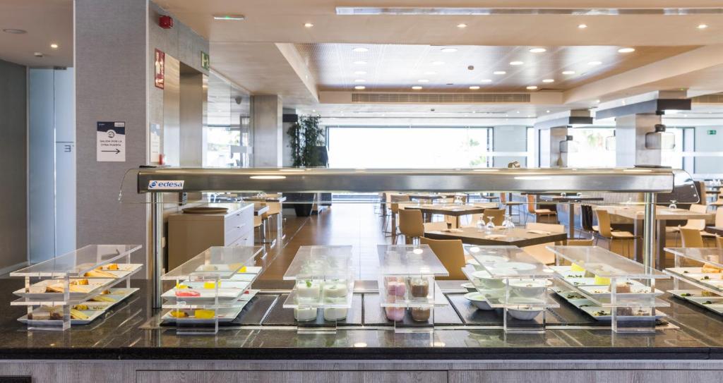 a buffet line with food on display in a restaurant at Ilunion Calas de Conil in Conil de la Frontera